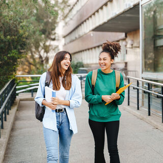 Student girl friends with learning books walking out School building